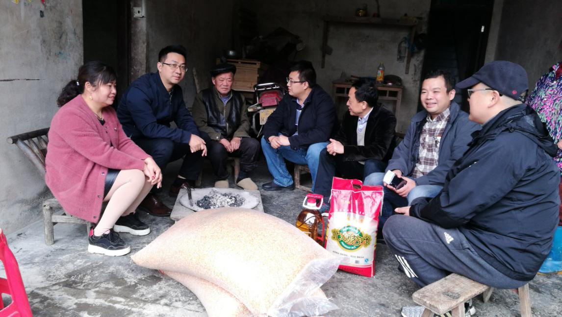 公司教师与贫困户进行交谈