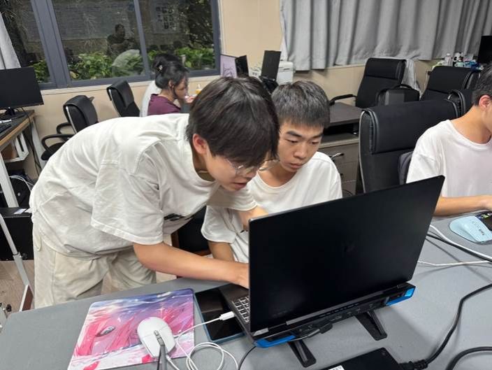 桌子上放着笔记本电脑的人描述已自动生成 桌子上放着笔记本电脑的人描述已自动生成
